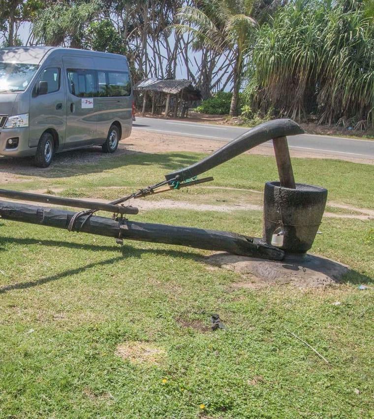 A traditional wooden press with a long beam and a large mortar
